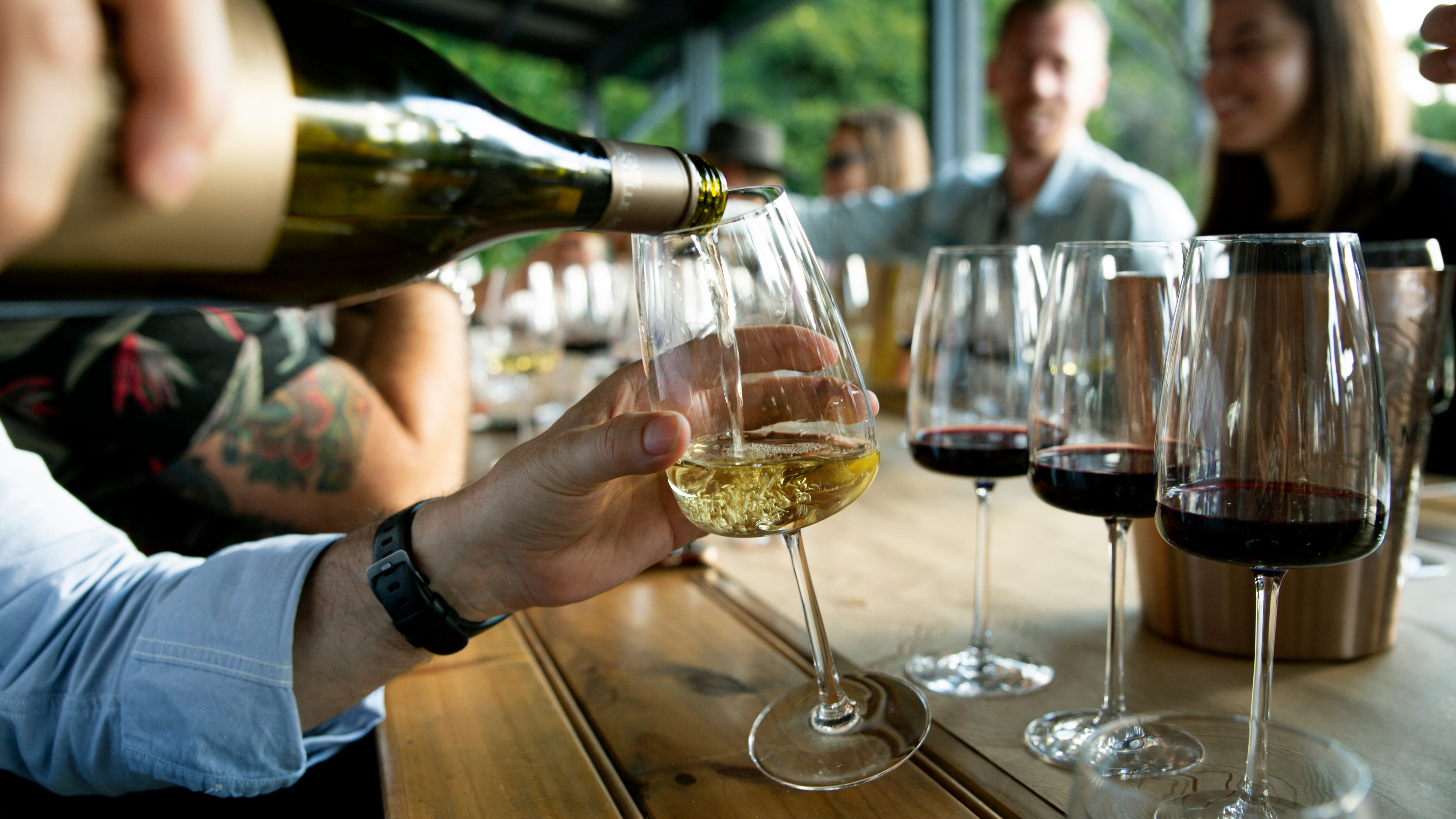 Hands pouring a glass of wine at a wine tasting